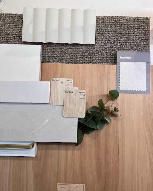 Flatlay with wood, white tiles, grey-white paint, plant