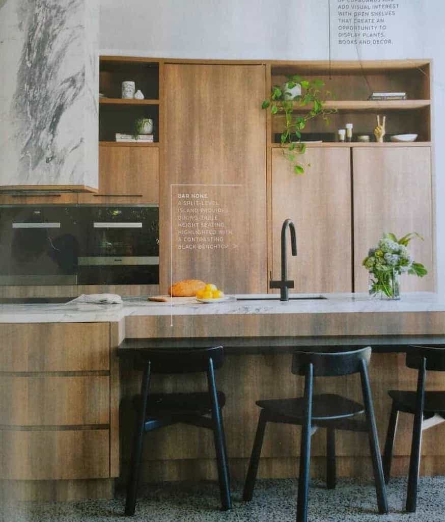 Kitchen with wood grain visible, black chairs arranged