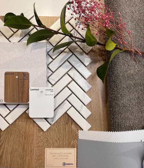 Angular white tiles dominating flatlay with grey carpet, wood, and flowers